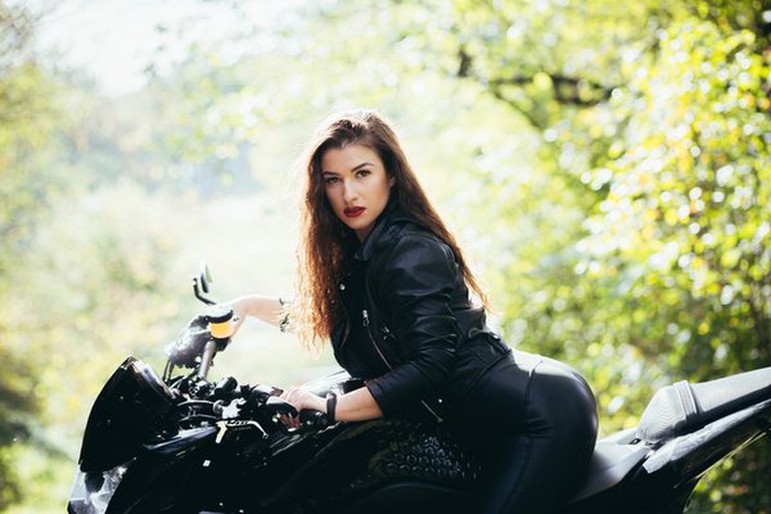 sexy biker woman in black leather pants